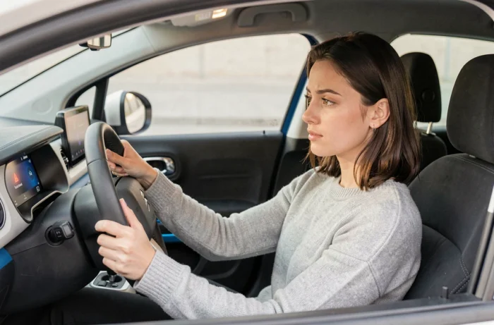 Conductrice observant un voyant allumé sur le tableau de bord de sa Citroën C3 électrique